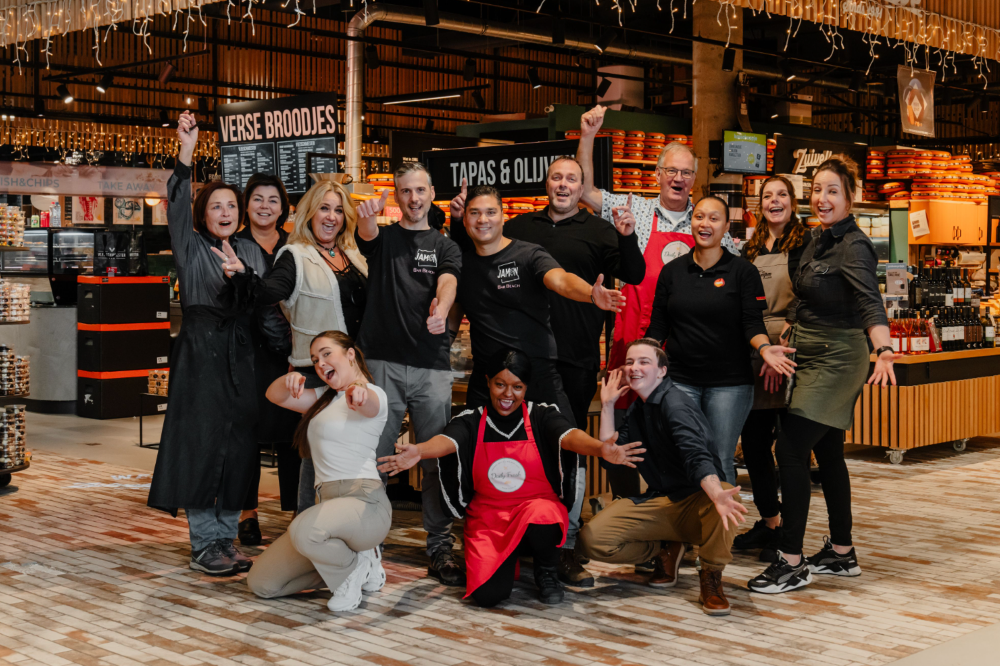Groep enthousiaste retail ondernemers in Nieuw Kijkduin poseert in Daily Taste.