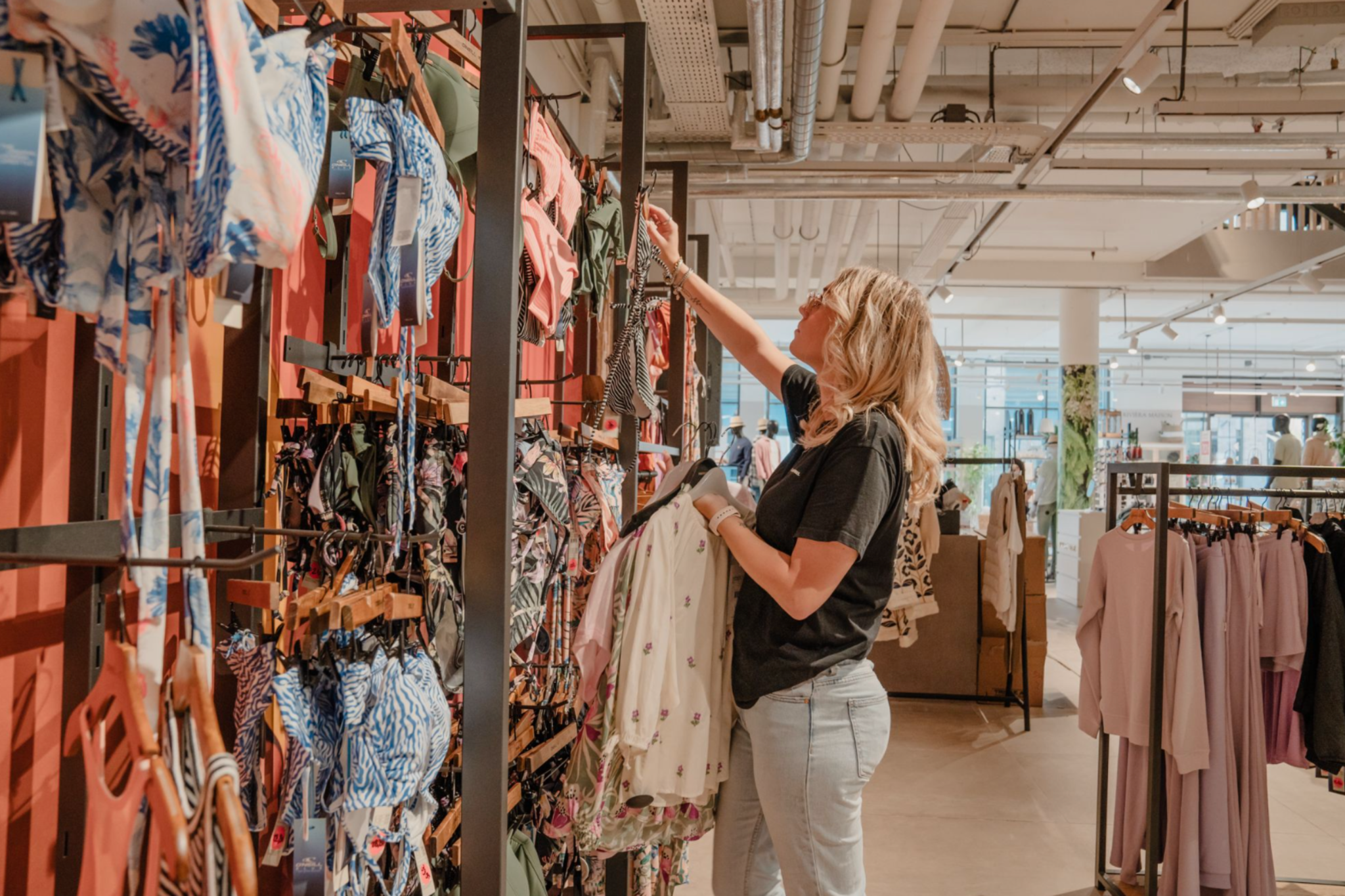 Klant kiest kleding in een winkel gerund door retail ondernemers in Nieuw Kijkduin.
